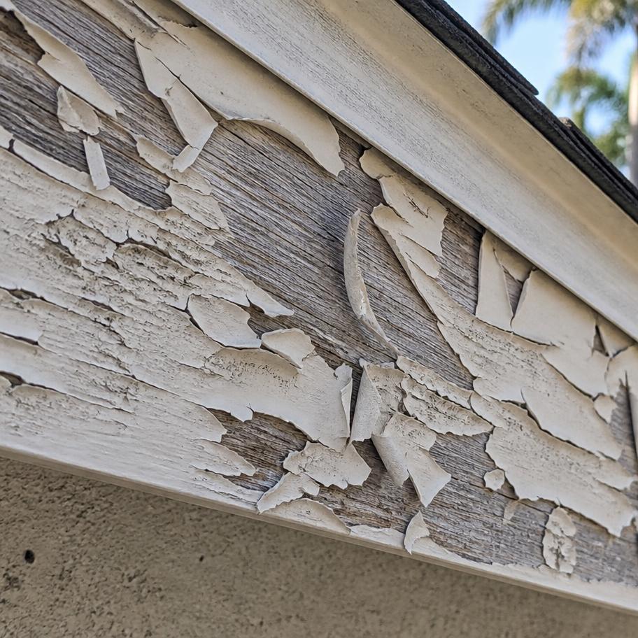 Paint peeling and curling off a wood fascia board